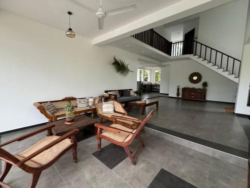 a living room with rocking chairs and a couch at Shades Hotel & Villa in Matara