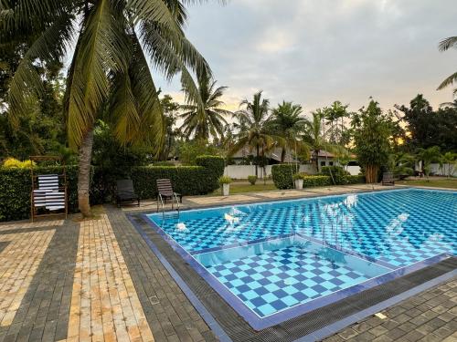 a swimming pool with blue tiles in a resort at Shades Hotel & Villa in Matara