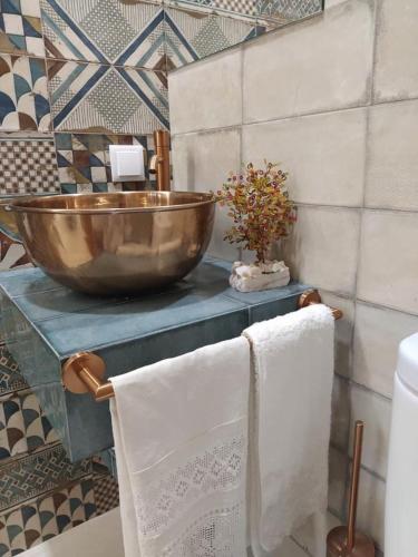 a bathroom with a large bowl sink and towels at Celeiro do Carvalho in Estela