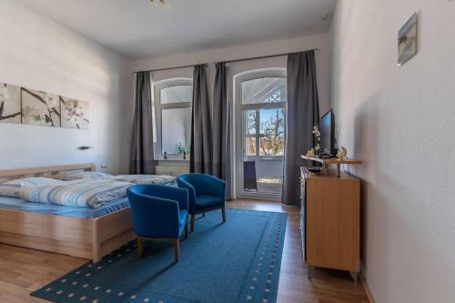 une chambre avec un lit, une télévision et une chaise dans l'établissement Villa-Seiler-in-Binz-3-Raum-Ferienwohnung-Nr-5-Toplage-wenige-Schritte-zum-Strand, à Binz