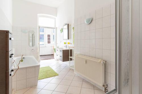 une salle de bain blanche avec une baignoire et un lavabo dans l'établissement Villa-Seiler-in-Binz-3-Raum-Ferienwohnung-Nr-5-Toplage-wenige-Schritte-zum-Strand, à Binz