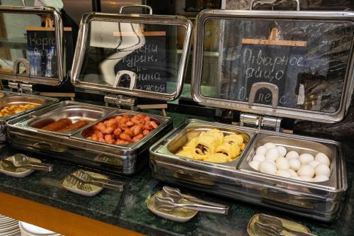 a buffet with trays of different types of food at Wyndham Garden Burabay in Borovoye