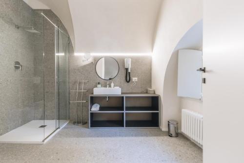 a bathroom with a sink and a glass shower at Foresteria Il Voltone in Cremona