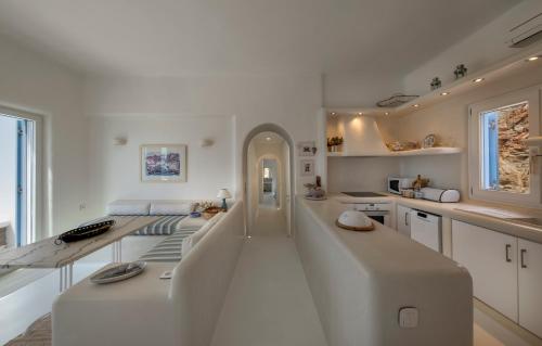 a white kitchen with a large white island in the middle at VILLA AGAPI KYTHNOS in Agios Dimitrios