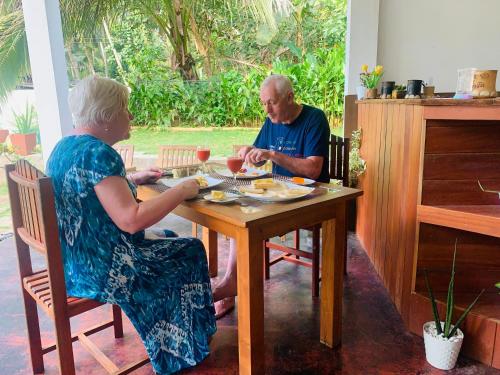 two older people sitting at a table eating food at Chill House safari resort in Udawalawe