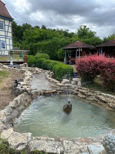 a small pond with a fountain in a yard at Feriendorf Slawitsch in Bad Sulza
