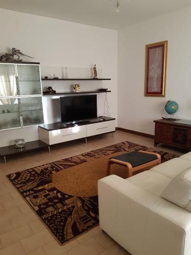 a living room with a white couch and a tv at La casa in più in Pesaro