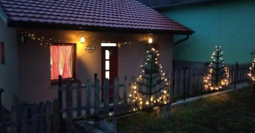 a house with a fence with christmas lights on it at Kuća Talija in Kalna