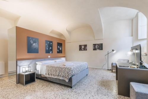 Habitación grande con cama y escritorio. en Foresteria Il Voltone, en Cremona