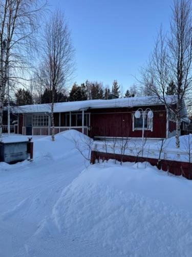 a house with snow on the ground in front of it at Tiitun Tupa Ivalo in Ivalo