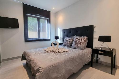 une chambre avec un grand lit avec une grande tête de lit dans l'établissement Chez K&D Appartement, piscine, mer 150m, à Grimaud