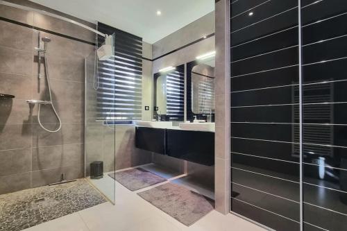 une salle de bain avec une douche, un lavabo et un miroir dans l'établissement Chez K&D Appartement, piscine, mer 150m, à Grimaud