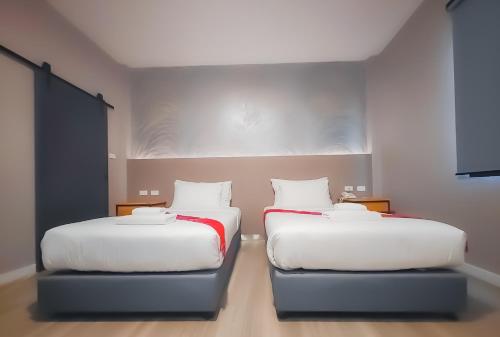 two beds sitting next to each other in a room at The Riva Vientiane Hotel in Vientiane