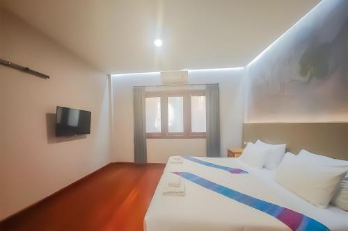a bedroom with a bed with a blue ribbon on it at The Riva Vientiane Hotel in Vientiane