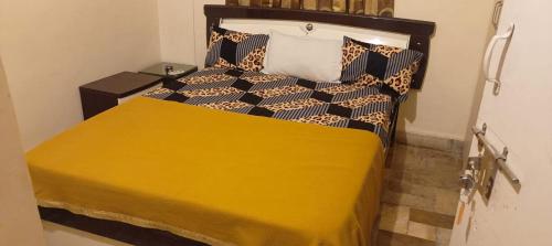 um quarto com uma cama grande e um cobertor amarelo em Lemon Tree Garden Villa em Pune