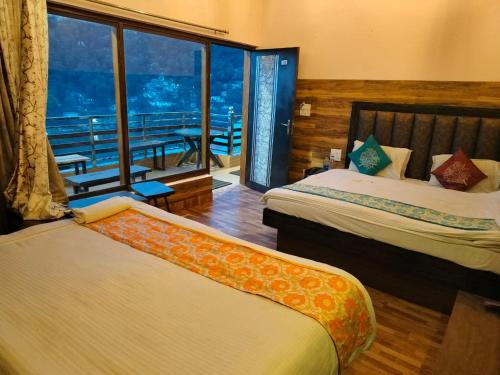 a hotel room with two beds and a large window at Hotel Surya Lake view in Nainital