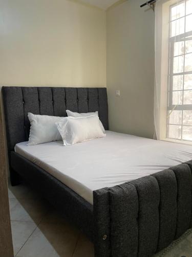 a large bed with a black headboard in a room at SNOWHAVEN BnB Kitengela in Kitengela 