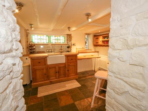 a large kitchen with a counter and a sink at Norden Cottage in Weymouth