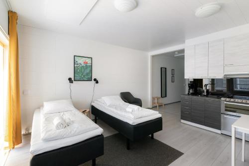 2 camas en una habitación con cocina en Hiisi Homes Sipoo Söderkulla, en Söderkulla