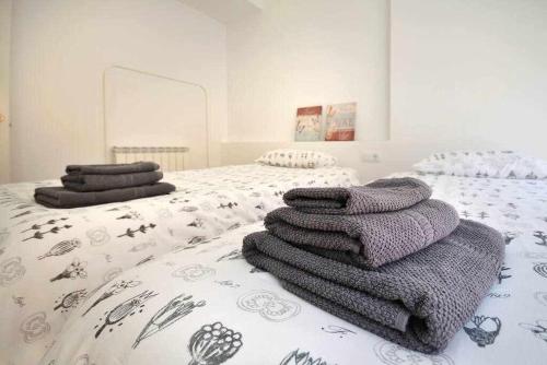 1 dormitorio con 2 camas y toallas. en Stunning apartment w amazing views and aircon, en Girona