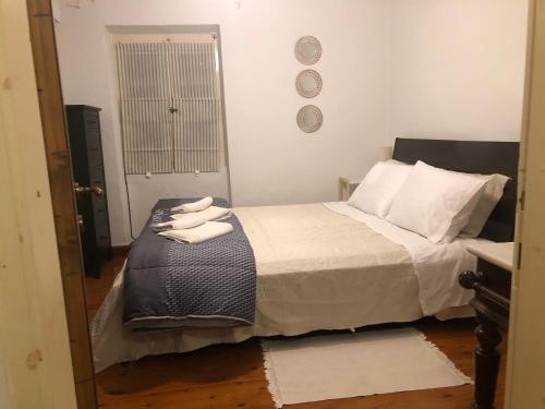 1 dormitorio con 1 cama con 2 toallas en Grandma’s old town house, en Corfú