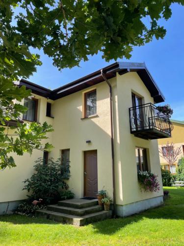 a house with a door and a balcony at Diuna in Dębki