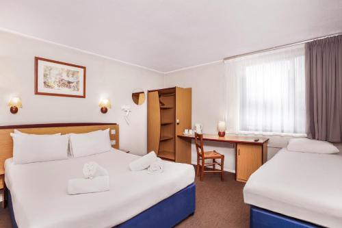 um quarto de hotel com duas camas e uma secretária em Campanile Manchester em Manchester
