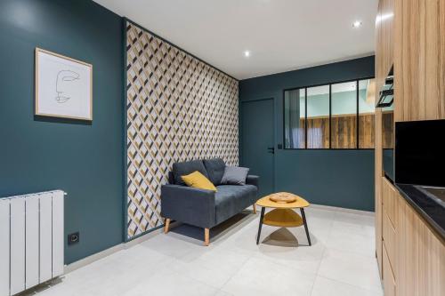 sala de estar con paredes azules y sofá azul en Hamac Suites - Suite du Parc 3 en Villeurbanne