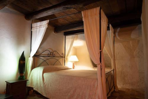 een slaapkamer met een hemelbed en gordijnen bij Domea Spa Borgo di Calcata in Calcata