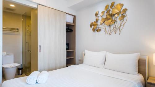 una camera da letto con un letto con due asciugamani bianchi di Уютные апартаменты в Laguna Skypark a Phuket