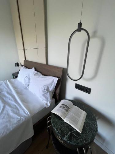 a bed with a table with a book on it at Art Studios Gialova Navarino in Gialova