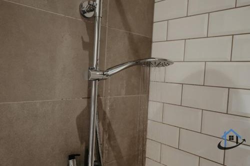 a shower with a shower head in a bathroom at Contemporary flat, sleeps 4, very central, parking in Northampton