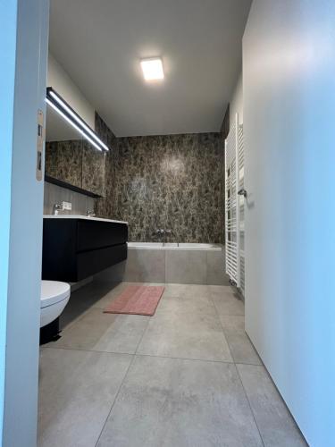 a bathroom with a tub and a toilet and a sink at Faro Greenpark, Cadzand-Bad APP 05 in Cadzand