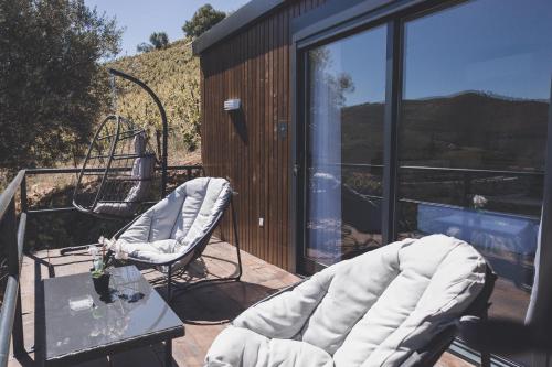 a balcony with a table and chairs on a house at Quinta da Portela Douro in Armamar