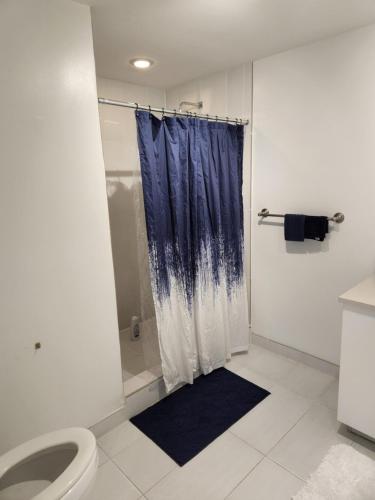 baño con ducha con cortina azul en Wonderful 1 bedroom condo in Midtown. en Miami