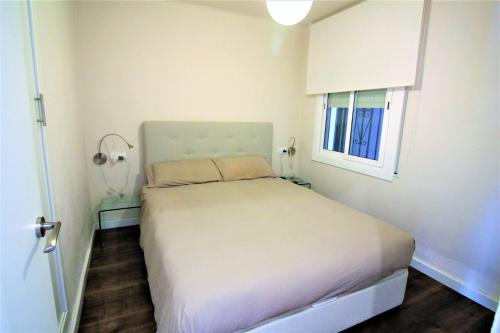 Un pequeño dormitorio con una cama blanca y una ventana en Global Immo 3338 NIRVANA, en Roses