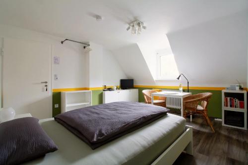a bedroom with a bed and a desk in it at Toms Gästehaus in Schleiden