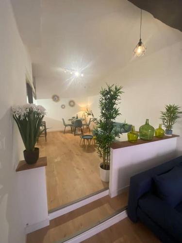 un salon avec des plantes en pot et une table dans l'établissement Loft - centre historique, à Villefranche-sur-Mer