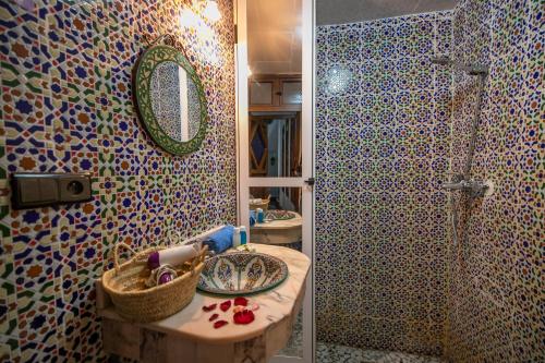a bathroom with a sink and a shower with a mirror at Riad Dar Rabha in Fez