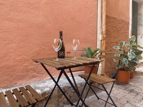 een houten tafel met twee wijnglazen en een fles bij Loft - centre historique in Villefranche-sur-Mer