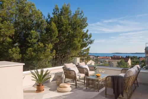 a patio with chairs and a table on a balcony at Villa Allegra Istriana in Fazana with sea view & spa in Fažana