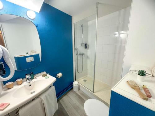 y baño azul con lavabo y ducha. en ibis Douai Centre, en Douai