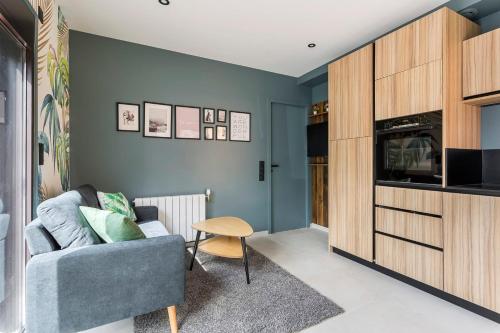 a living room with a couch and a tv at Hamac Suites - Suite Parc 1 in Villeurbanne