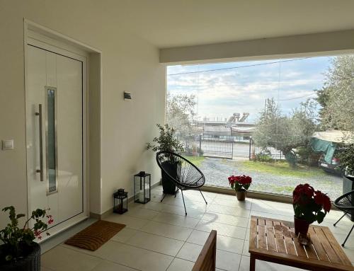 a living room with a large window with a view of a yard at Chic Apartment in Nature in Kalamata