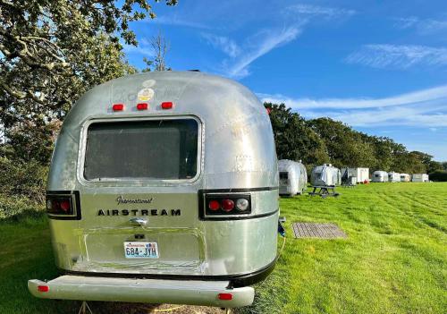 an old airstream trailer parked in a field at Retro Staycations in Ryde