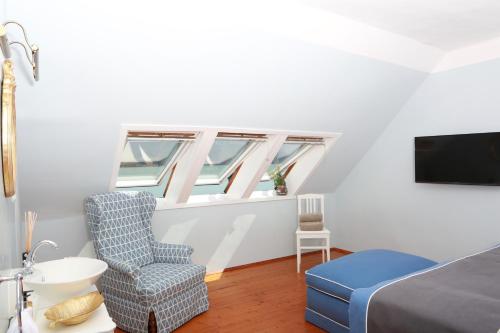 阿特湖的住宿－Villa Weiss，一间卧室配有一张床、一把椅子和电视。