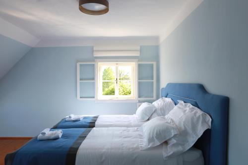 a blue bedroom with a bed with a window at Villa Weiss in Attersee am Attersee