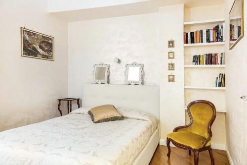 a bedroom with a bed and a yellow chair at Menotti elegant Apartment in Rome