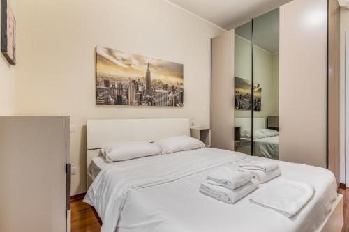 a bedroom with a white bed with towels on it at Milano Via Del Fusaro 4 PAX Wi-Fi in Milan