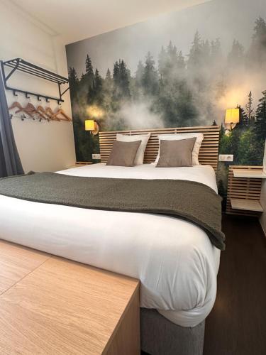 een slaapkamer met een groot bed en een schilderij aan de muur bij Auberge du Vieux Lanas Logis Hotel Restaurant in Lanas